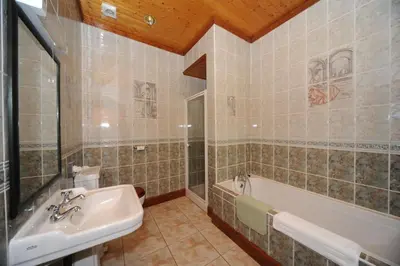 a bathroom with a sink and a bath tub at Craigard House Hotel in Campbeltown