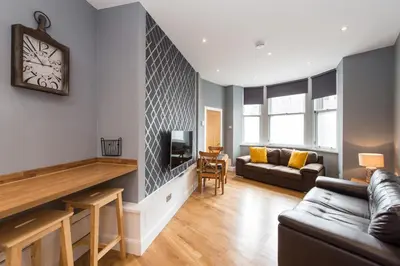 a living room with a couch and a tv at Castle apt, modern, CENTRAL in Edinburgh