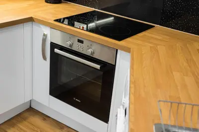 a stove top oven in a kitchen with white cabinets at Castle apt, modern, CENTRAL in Edinburgh