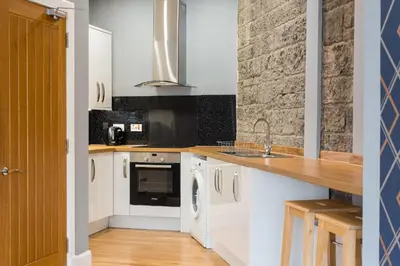 a kitchen with white cabinets and a sink at Castle apt, modern, CENTRAL in Edinburgh