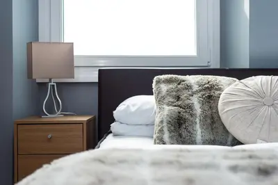 a bedroom with a bed with a pillow and a lamp at Castle apt, modern, CENTRAL in Edinburgh