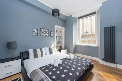 a bedroom with a bed with a black and white blanket at City Centre, 5 star Ground Floor in Edinburgh