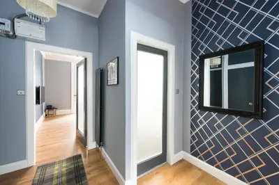 a hallway with blue walls and a mirror at City Centre, 5 star Ground Floor in Edinburgh