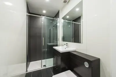 a bathroom with a glass shower and a sink at City Centre, 5 star Ground Floor in Edinburgh