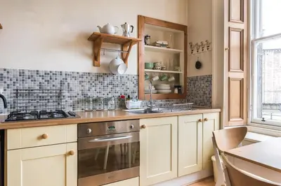 a kitchen with white cabinets and a sink and a stove at Spacious & Unique city central 1 bed with WiFi in Edinburgh