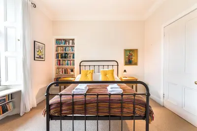 a bedroom with a bed with yellow pillows at Spacious & Unique city central 1 bed with WiFi in Edinburgh