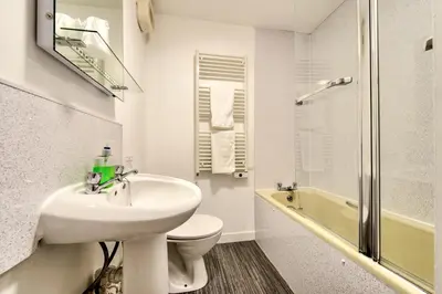 a bathroom with a sink and a toilet and a shower at Charming 1 Bed Apartment with Castle View in Edinburgh