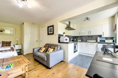 a living room with a couch and a kitchen at Stunning Studio Apartment Castle View in Edinburgh