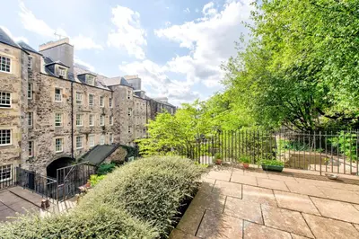 a courtyard in front of a building with a fence at Stunning Studio Apartment Castle View in Edinburgh