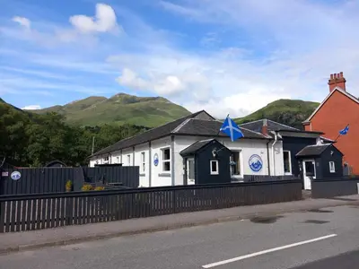 a white building with a blue star on top of it at Nevis Pod, West Highland Way Holidays in Kinlochleven