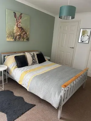 a bedroom with a bed with a picture of a rabbit on the wall at The Grey Cottage in Blackford