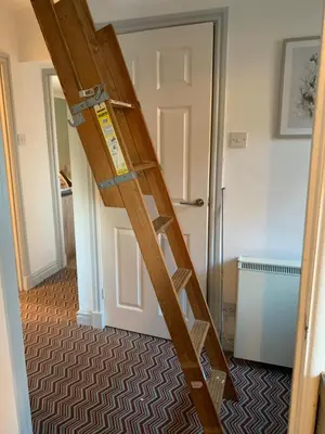 a wooden ladder in a room with a door at The Grey Cottage in Blackford