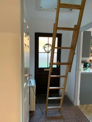 a wooden ladder in a room with a door at The Grey Cottage in Blackford