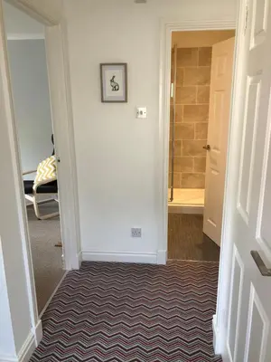 a hallway with a door leading to a bathroom at The Grey Cottage in Blackford