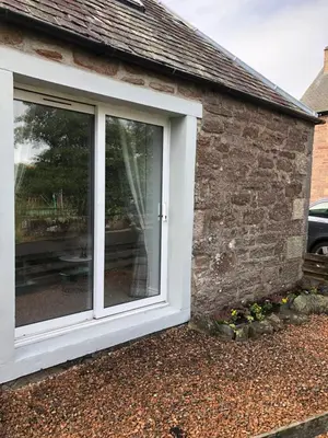 a white window on the side of a house at The Grey Cottage in Blackford