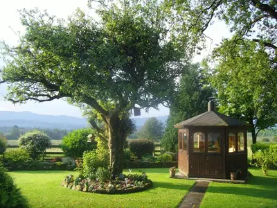 a small house in a yard with a tree at Lower Balwill in Buchlyvie