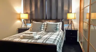 a bedroom with a large bed with two lamps at Elegant Apartment Near SECC/HYDRO in Finnieston, Glasgow in Glasgow
