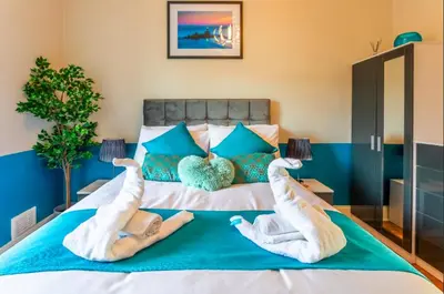 two people are laying on a bed with their legs up at Clyde View Apartment in Helensburgh