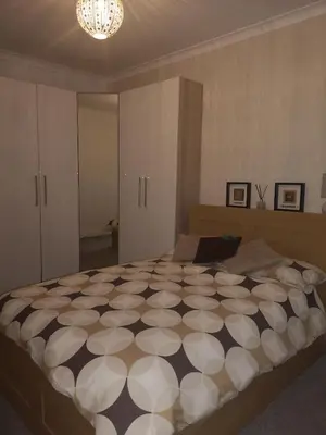 a bedroom with a large bed with a black and white comforter at Sleep Well Apartment in Glasgow