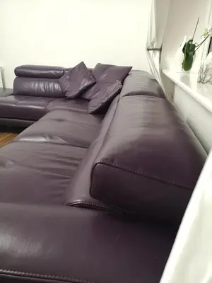 a group of leather couches in a room at Sleep Well Apartment in Glasgow