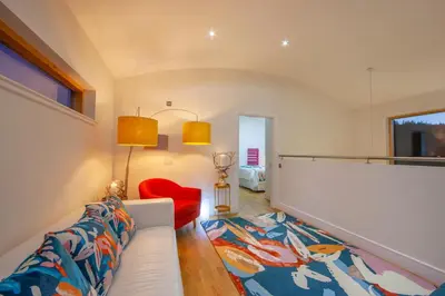 a living room with a white couch and a red chair at Ardtorna in Benderloch