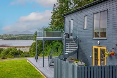 a house with a staircase and a view of the water at Ardtorna in Benderloch