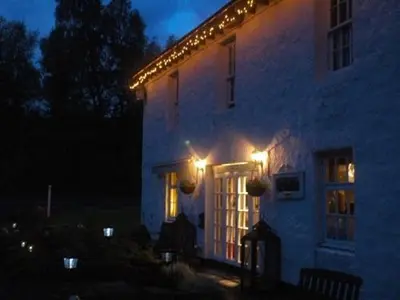 a building with lights on the side of it at night at Luib Hotel in Killin
