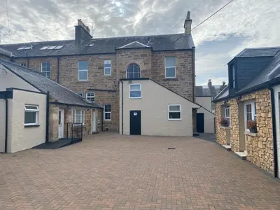a large brick building with a large driveway at Miller House Courtyard in Ayr