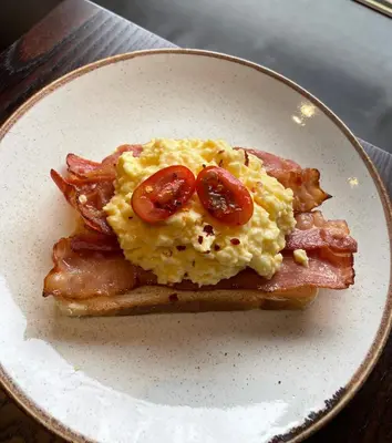 a breakfast sandwich with eggs and bacon on a plate at The Ranald Hotel in Oban