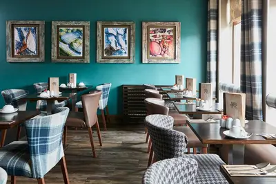 a row of tables and chairs in a restaurant at The Ranald Hotel in Oban