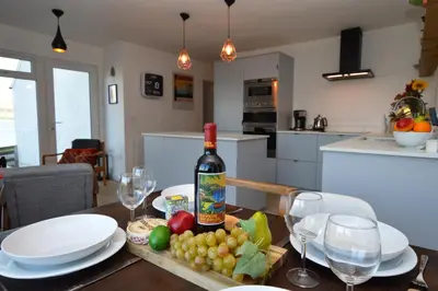a bottle of wine sitting on a table with glasses at Gate Cottage in Tighnabruaich