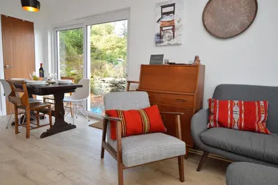 a living room with a table and a chair and a table at Gate Cottage in Tighnabruaich