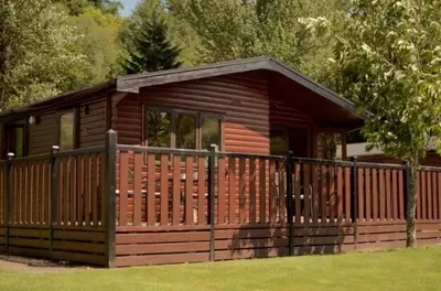 a small wooden cabin with a wooden fence at Caol Gleann Lodge in Rowardennan