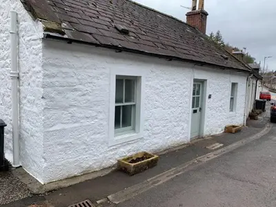 a white building with a window and a roof at Boggle Dyke Cottage in Thornhill