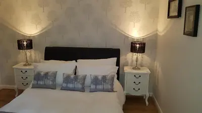a bedroom with a white bed with two night stands at Largs stay With Private parking in Largs