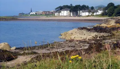 a view of a beach with houses in the background at Largs stay With Private parking in Largs