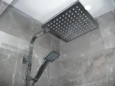a shower with a shower head in a bathroom at Westpark Apartment in East Kilbride