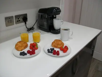 a table with two plates of food and two cups of coffee at Westpark Apartment in East Kilbride