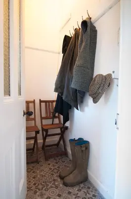 a hallway with a bunch of clothes and boots at Neidpath Castle Cottage in Peebles