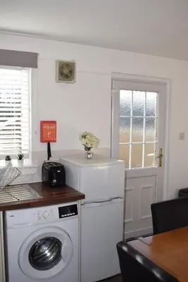 a kitchen with a washing machine and a window at Kelpies Serviced Apartments-McKay in Falkirk
