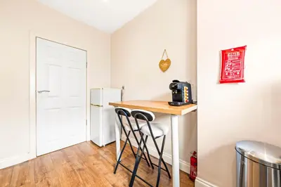 a small kitchen with a counter and a refrigerator at Three Bed Holiday Home in Glasgow in Glasgow