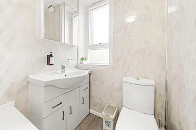 a white bathroom with a sink and a toilet at Three Bed Holiday Home in Glasgow in Glasgow