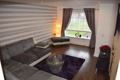 a living room with a couch and a window at Silverburn new house with free parking and nice garden in Glasgow