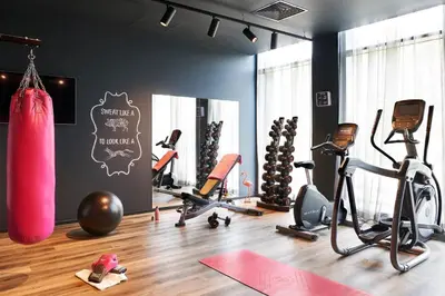 a gym with exercise equipment in a room at Moxy Edinburgh Airport in Ingliston