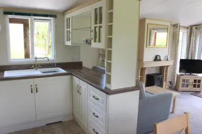 a kitchen with white cabinets and a sink at Ben View in Taynuilt