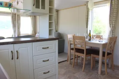 a kitchen and dining room with a table and chairs at Ben View in Taynuilt
