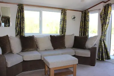 a living room with a couch and two windows at Loch View in Taynuilt