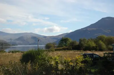 a car parked in a field next to a lake at Loch View in Taynuilt