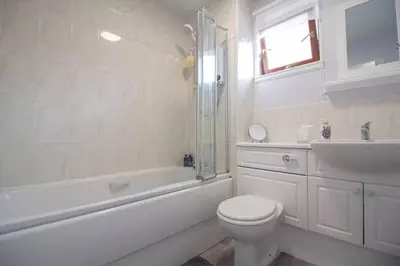 a white bathroom with a toilet and a sink at South Groathill - Lovely 2 bed with Castle View in Edinburgh