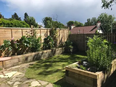 a garden with a wooden fence and some plants at A Wee Cottage In Dunfermline in Dunfermline
